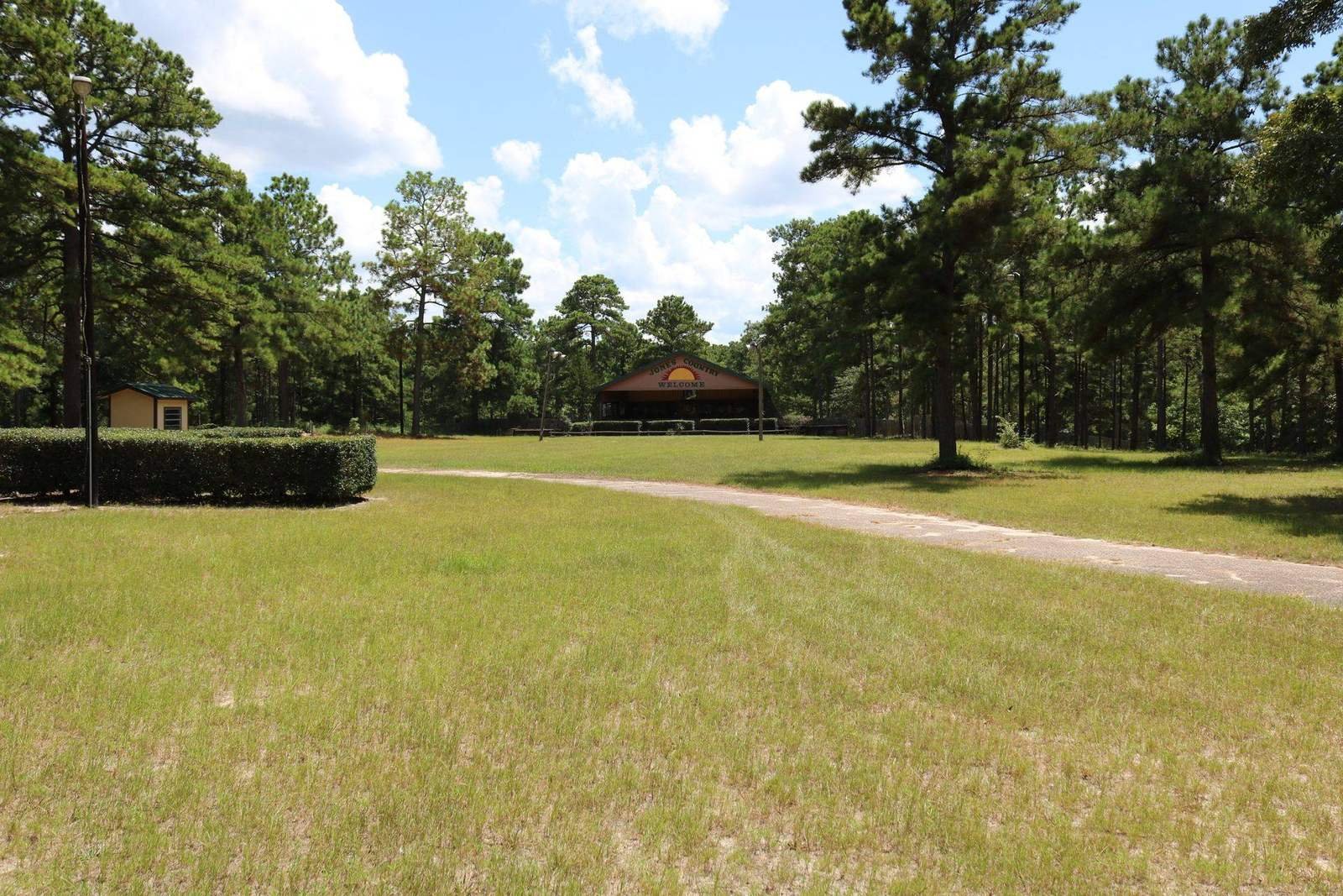 Looking down a pine-lined lawn toward the Jones Country stage